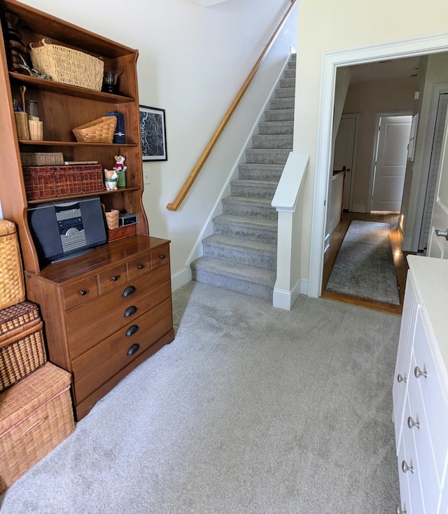 stairway with baseboards and carpet floors
