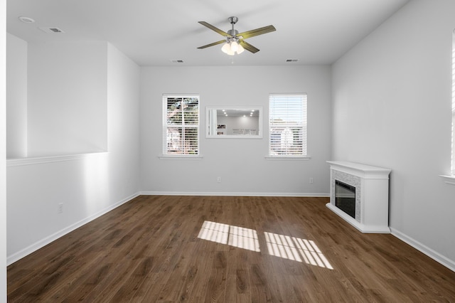 unfurnished living room with dark hardwood / wood-style flooring, ceiling fan, and a wealth of natural light