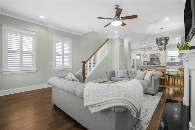 living room featuring dark wood finished floors, a ceiling fan, baseboards, and ornamental molding