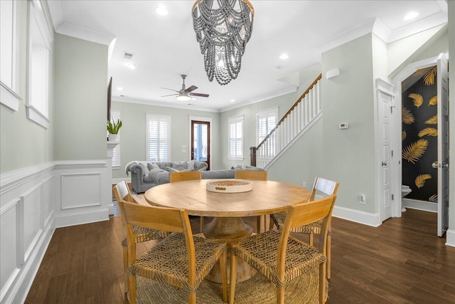 dining room with ceiling fan with notable chandelier, stairway, wood finished floors, and ornamental molding