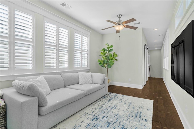 living room with ceiling fan, wood finished floors, visible vents, and baseboards