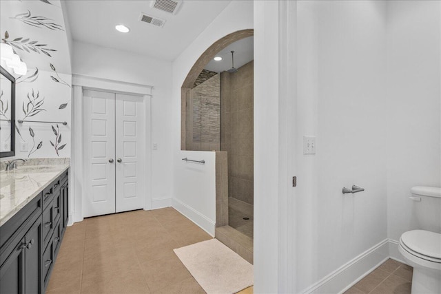 bathroom with tile patterned floors, visible vents, toilet, and walk in shower