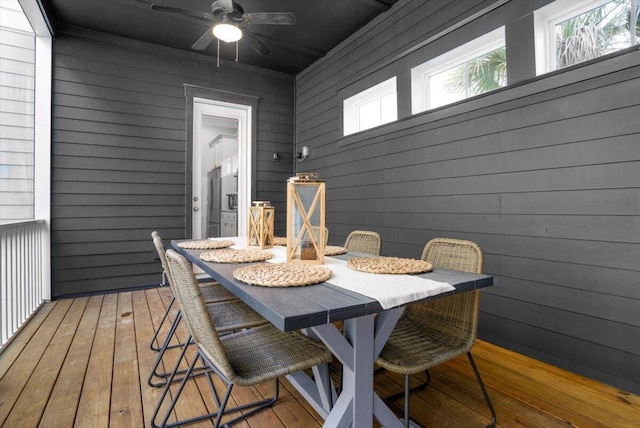 wooden terrace featuring outdoor dining area and ceiling fan