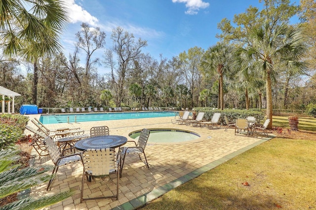 community pool with a patio and a community hot tub