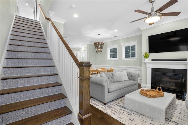 stairs featuring visible vents, ceiling fan with notable chandelier, recessed lighting, wainscoting, and crown molding