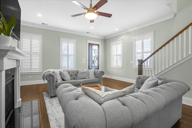 living area featuring dark wood-style floors, baseboards, ceiling fan, and ornamental molding