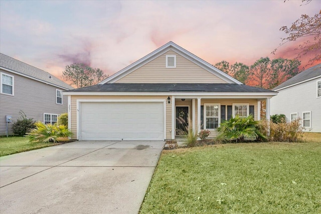 view of front of home with a garage and a lawn