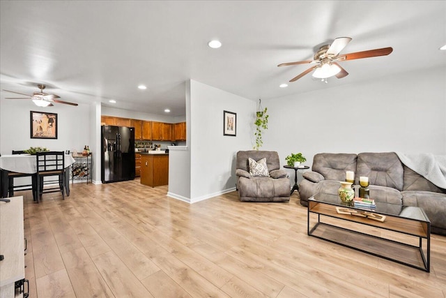 living room with ceiling fan and light hardwood / wood-style floors