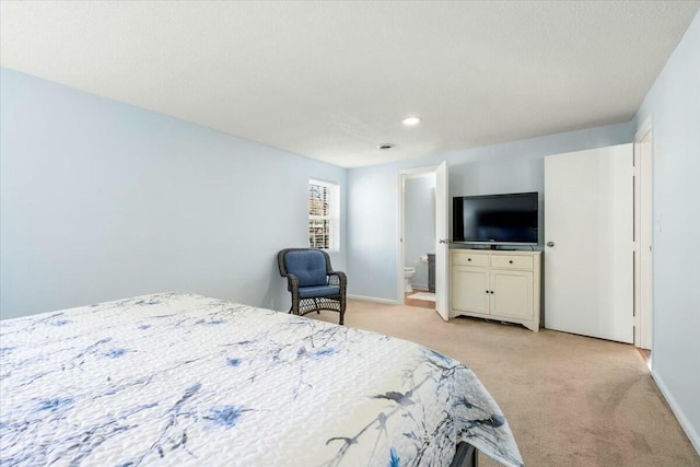 bedroom featuring light colored carpet and connected bathroom