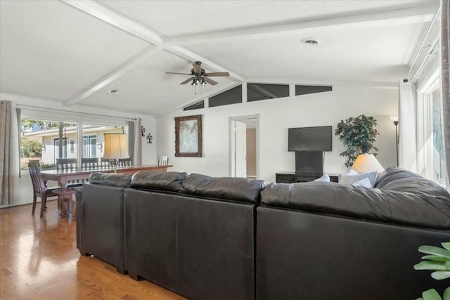 living room featuring ceiling fan, lofted ceiling with beams, and hardwood / wood-style floors