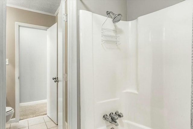 bathroom featuring tile patterned floors, toilet, shower / bathing tub combination, and a textured ceiling