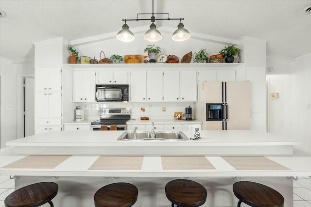 kitchen with stainless steel electric stove, sink, a kitchen bar, hanging light fixtures, and white refrigerator with ice dispenser