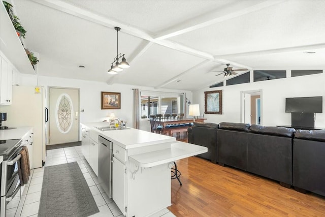 kitchen with sink, stainless steel appliances, a center island, white cabinets, and decorative light fixtures