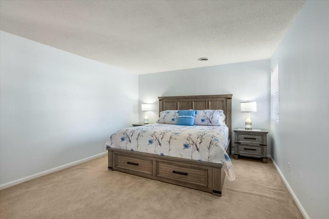 bedroom with light carpet and a textured ceiling