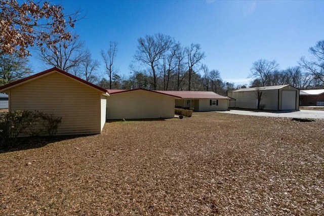 rear view of property with an outbuilding and a garage