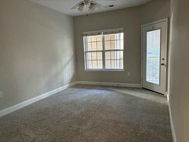 carpeted spare room featuring ceiling fan