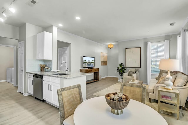 dining area featuring light wood-type flooring, baseboards, visible vents, and crown molding