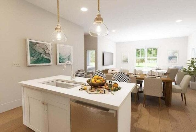 kitchen with pendant lighting, sink, stainless steel dishwasher, light wood-type flooring, and an island with sink