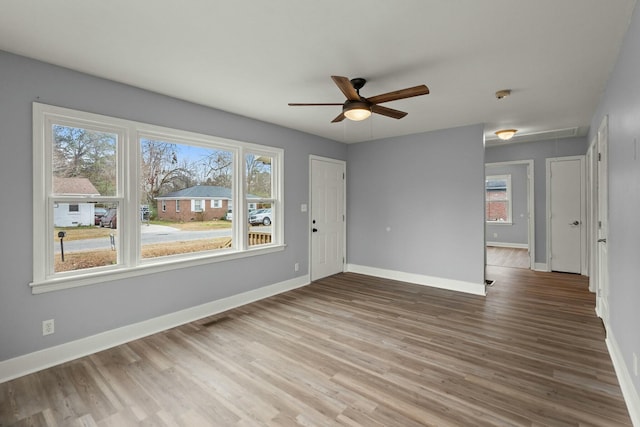 unfurnished room featuring hardwood / wood-style flooring, ceiling fan, and plenty of natural light