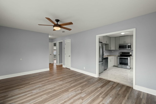 unfurnished living room with ceiling fan and light wood-type flooring