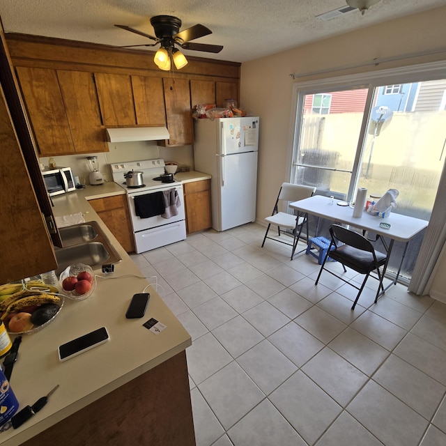 kitchen with sink, light tile patterned floors, white appliances, ceiling fan, and a textured ceiling