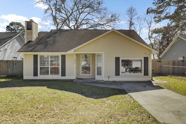 view of front facade with a chimney, a front yard, and fence