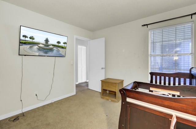 bedroom featuring light colored carpet and baseboards