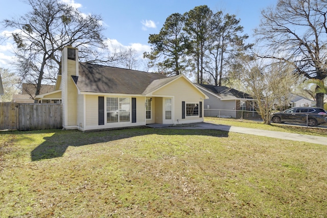 view of front of home with a front lawn, fence, and a chimney