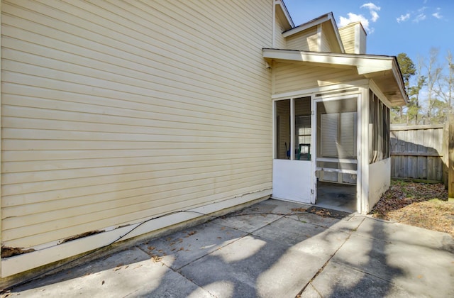 view of side of property featuring a patio area and fence