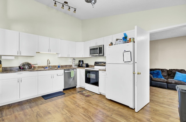 kitchen featuring a sink, stainless steel appliances, white cabinets, and light wood-style flooring