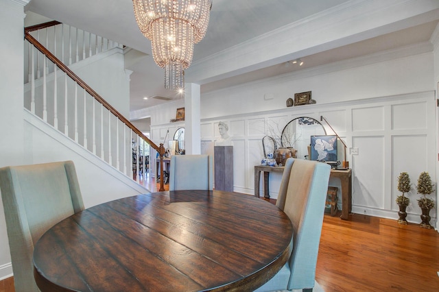 3306 Hartwell St, Johns Island, SC 29455 - dining room with a chandelier, stairs, wood finished floors, crown molding, and a decorative wall
