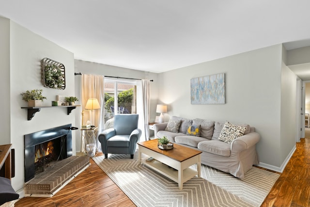 living room featuring wood-type flooring and a brick fireplace