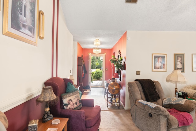 living area with visible vents, a textured ceiling, and light colored carpet