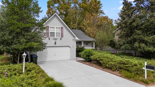 view of front of house featuring a garage, driveway, and fence