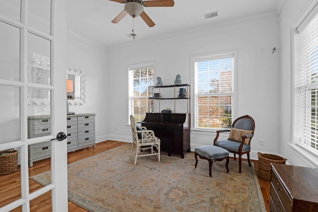 office featuring ceiling fan, wood-type flooring, and ornamental molding