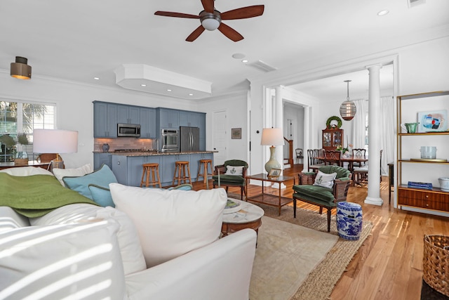 living room featuring ornamental molding, ornate columns, ceiling fan, and light hardwood / wood-style flooring