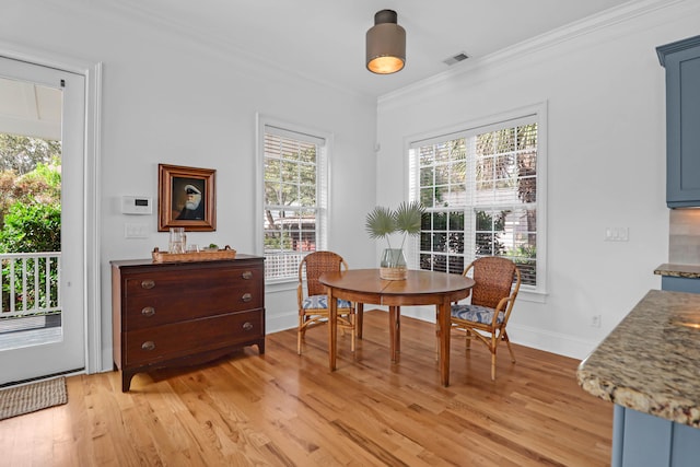 dining area featuring light wood-type flooring and ornamental molding