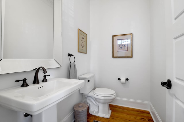 bathroom with toilet, hardwood / wood-style flooring, and sink