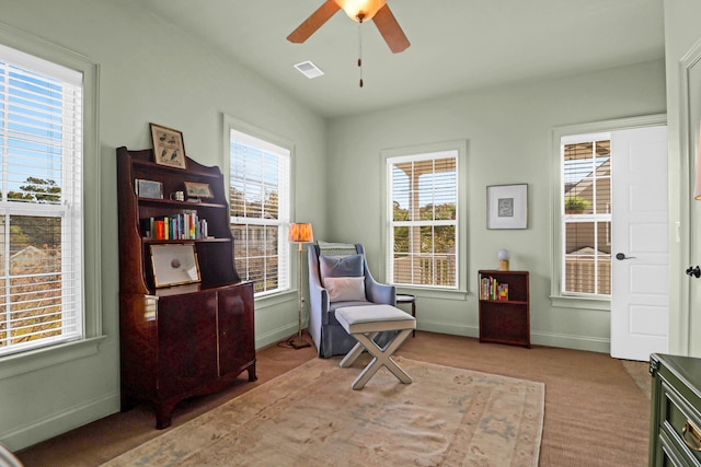 sitting room featuring ceiling fan, plenty of natural light, and light colored carpet