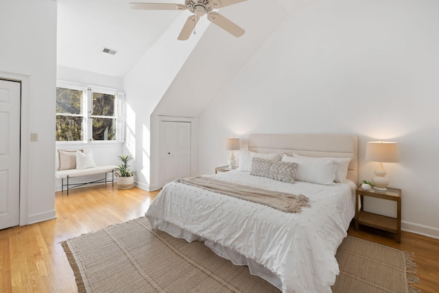 bedroom featuring visible vents, ceiling fan, baseboards, vaulted ceiling, and wood finished floors