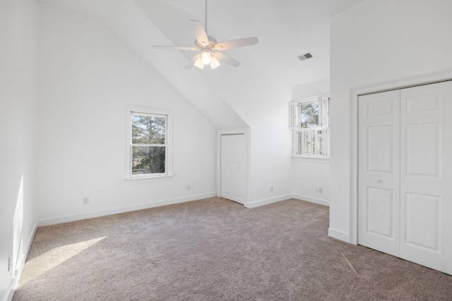 additional living space featuring lofted ceiling, carpet, visible vents, and a healthy amount of sunlight