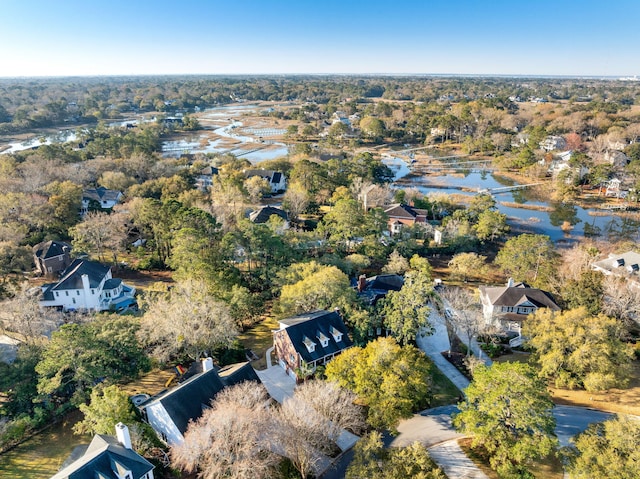 drone / aerial view featuring a wooded view and a water view