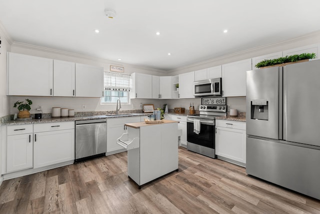 kitchen with white cabinets, sink, a kitchen island, and stainless steel appliances