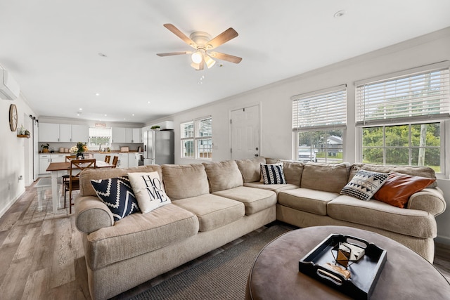 living room with ceiling fan, light hardwood / wood-style floors, and ornamental molding