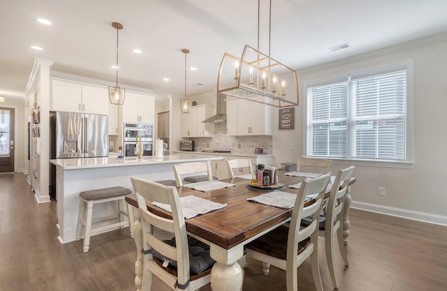 dining space featuring dark hardwood / wood-style flooring and crown molding