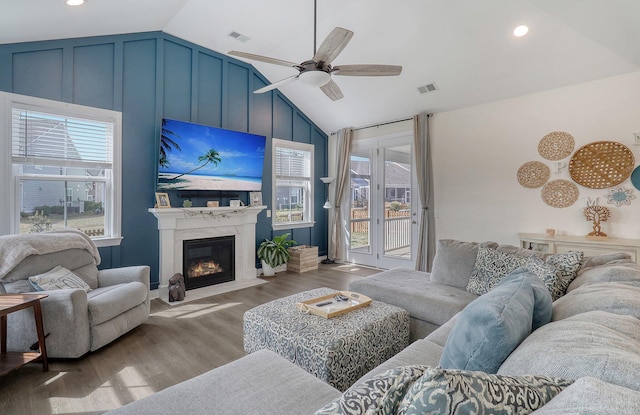 living room featuring hardwood / wood-style flooring, lofted ceiling, ceiling fan, and a fireplace