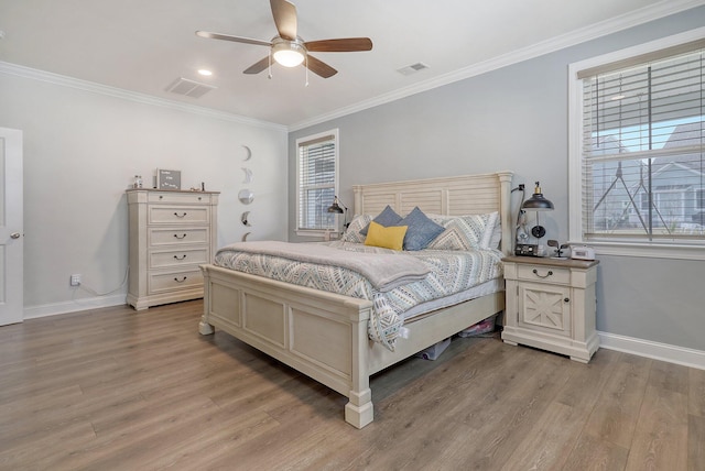 bedroom featuring light hardwood / wood-style floors, ornamental molding, and ceiling fan