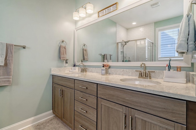 bathroom featuring a shower with shower door, double vanity, and tile floors