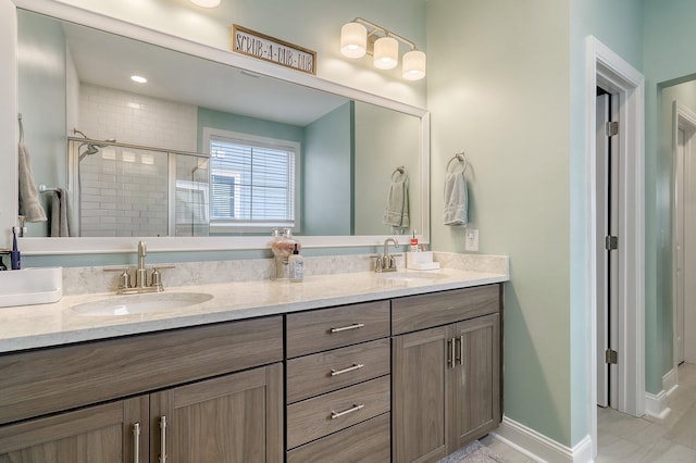 bathroom featuring tile floors, dual sinks, vanity with extensive cabinet space, and a shower with door