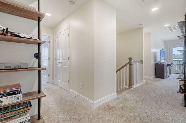 hall with light colored carpet